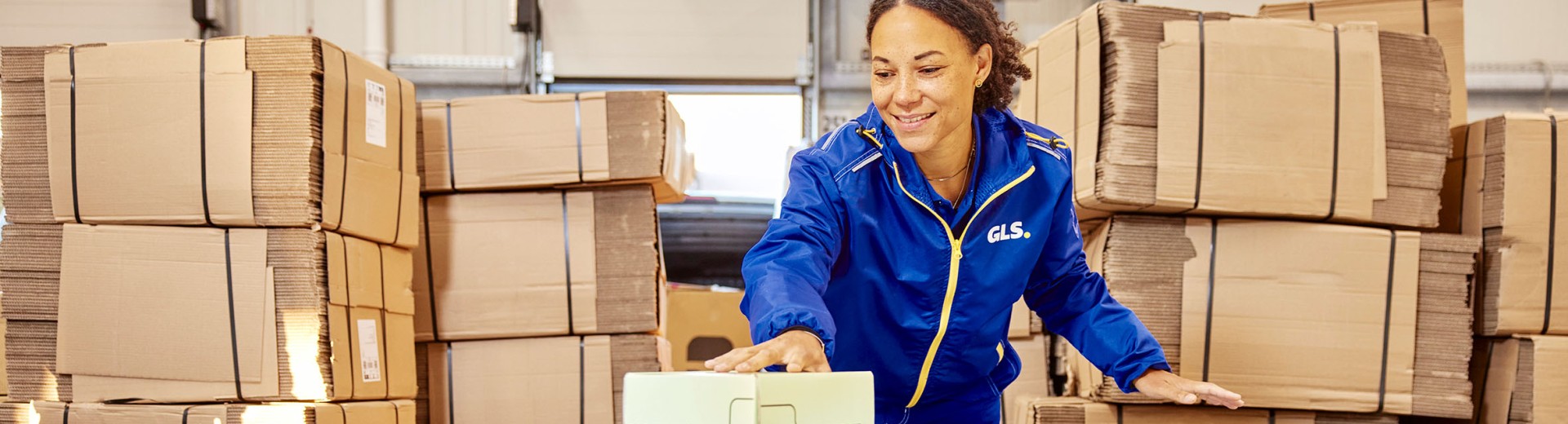 Mitarbeiterin im GLS-Depot beim Pakete nach England senden 