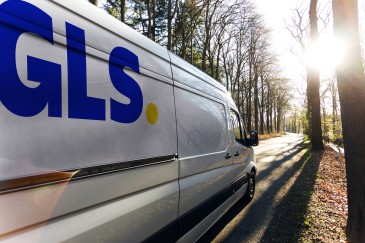 GLS-bezorger haalt pakket uit de bestelwagen voor bezorging