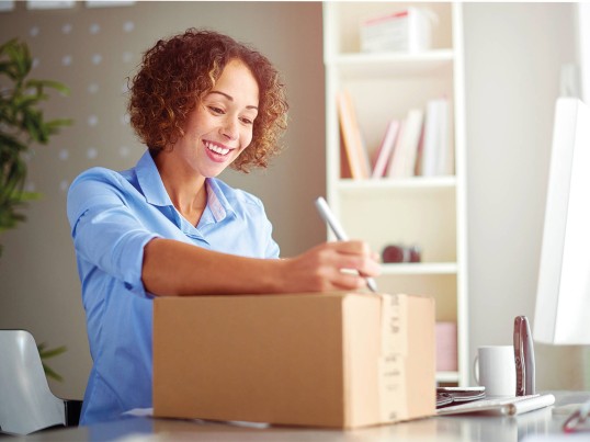 woman smiling and looking at a package
