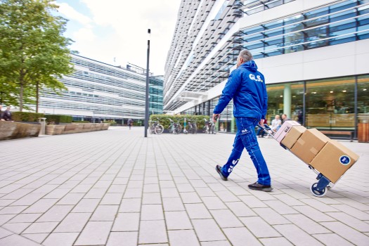 GLS-työntekijä kuljettaa paketteja kaupungilla