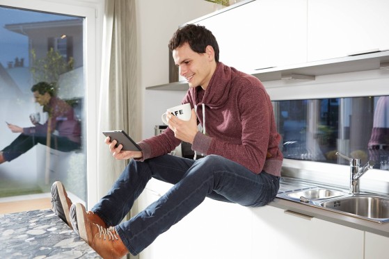 Customer using the GLS app on his phone, sitting on counter