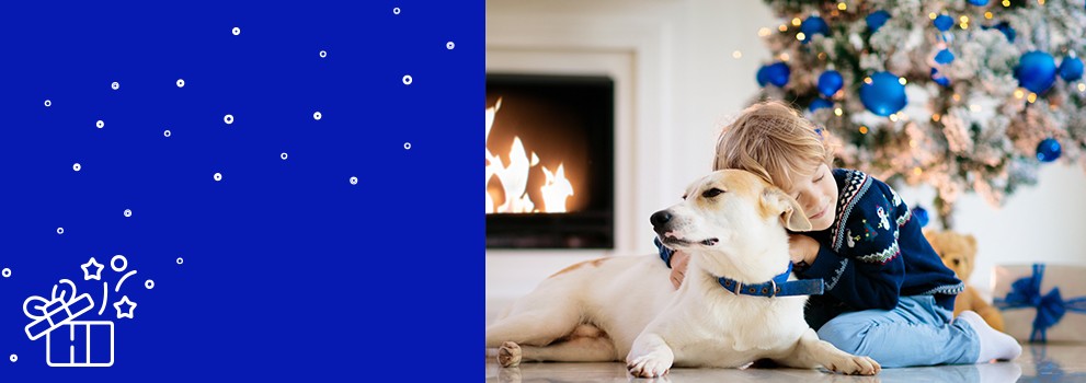 bambino e cane davanti all'albero di Natale